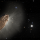 A cigar-shaped reddish-brown rock in the foreground of this artist's impression is 'Oumuamua, passing through our solar system.